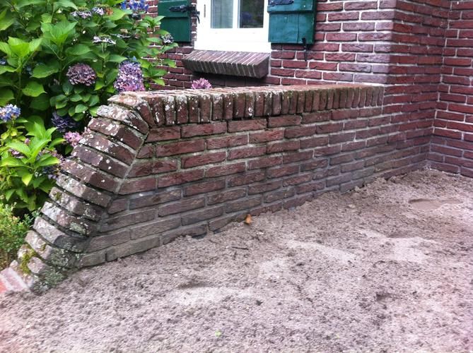 Stenen muur als borderafscheiding in tuin Werkspot