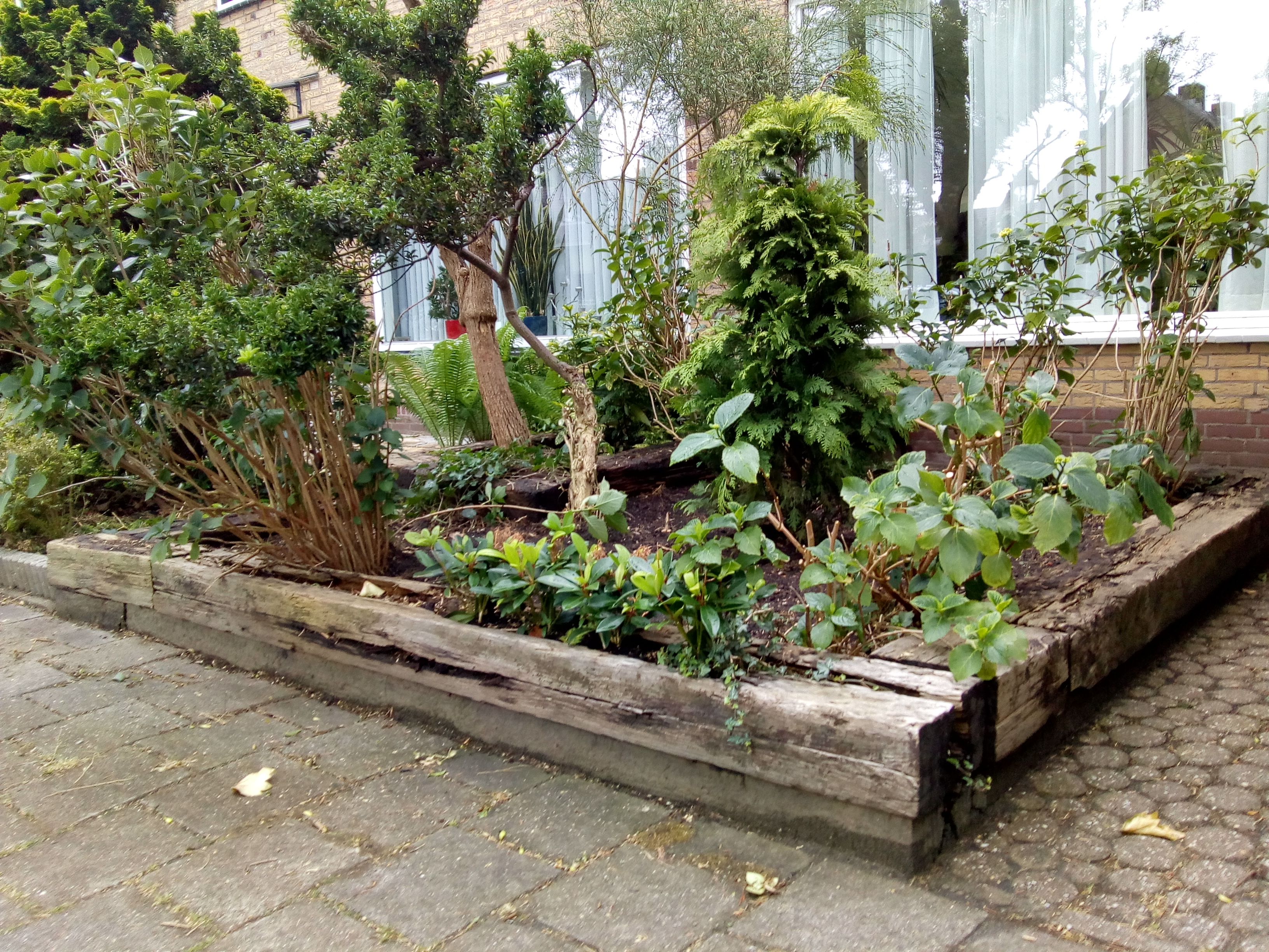 Tuinonderhoud Nieuwe houten bielzen in de voortuin en oude afvoeren