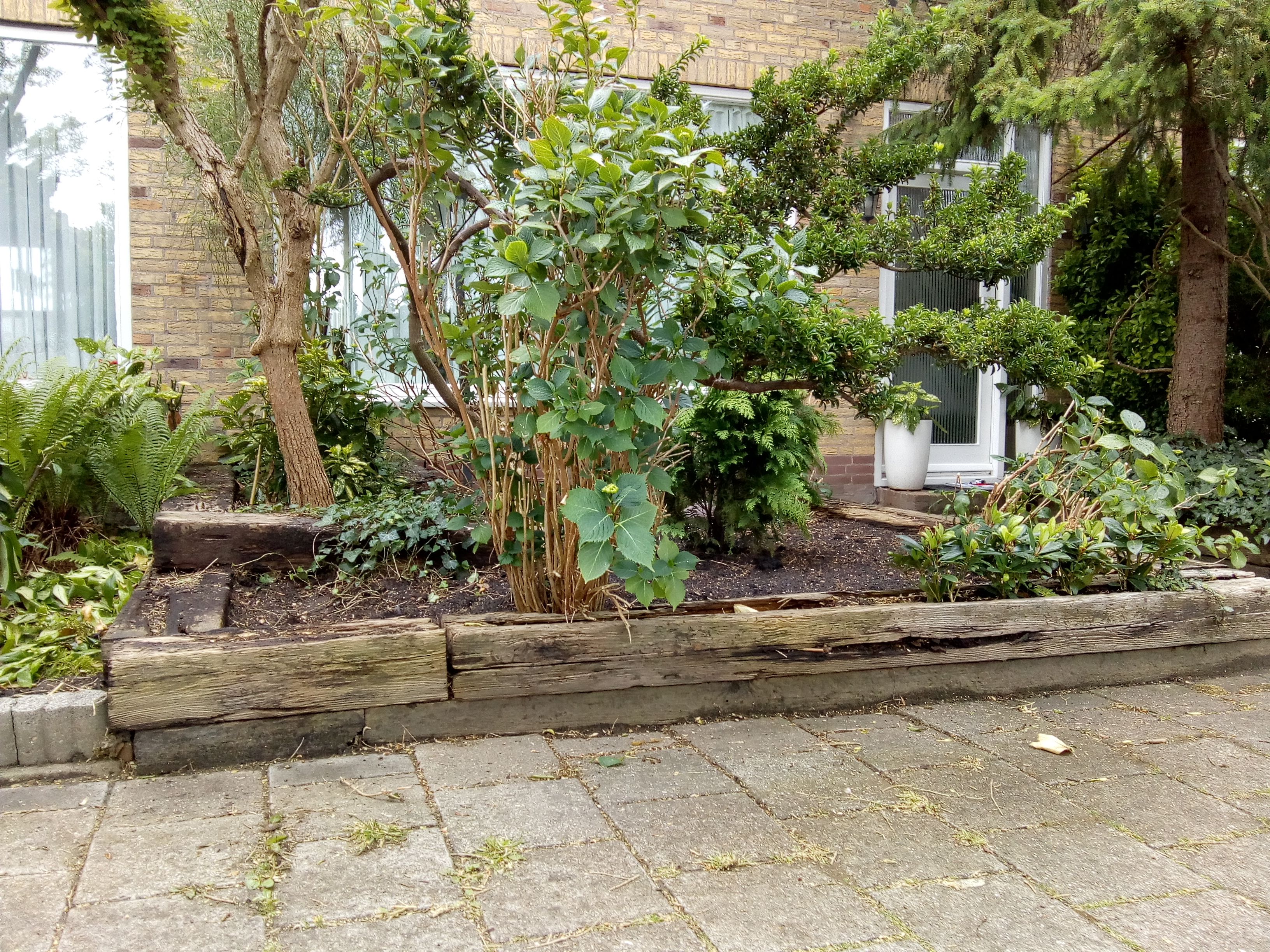 Tuinonderhoud Nieuwe houten bielzen in de voortuin en oude afvoeren